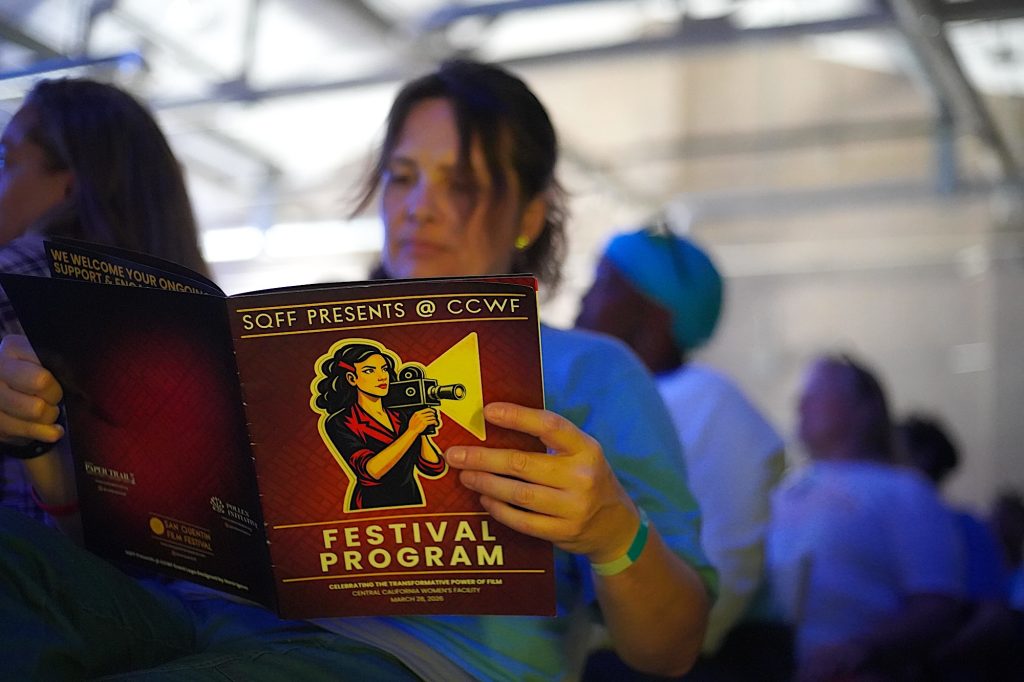 Incarcerated woman looks at film festival program