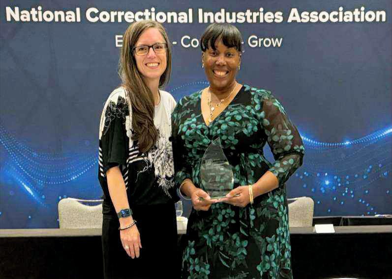 Ironwood State Prison’s CALCTRA Correctional Training Manager, Valerie Dupree, stands with her award at “National Correctional Industries Association” conference.