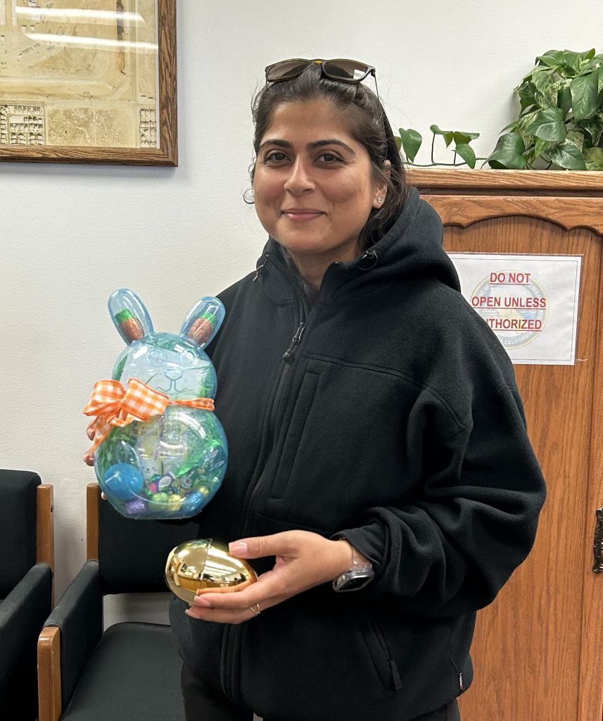 LAC staff member with golden egg and prize.