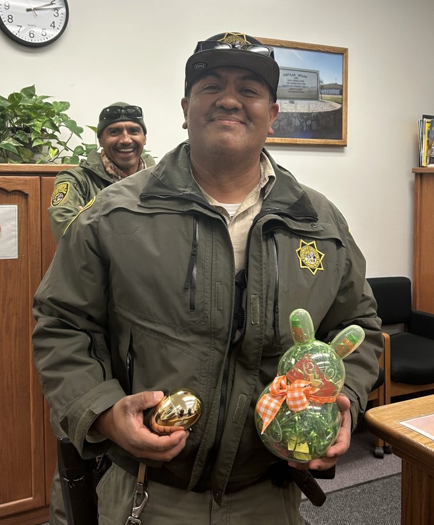 A correctional officer with an egg and prize in the warden's office at LAC.