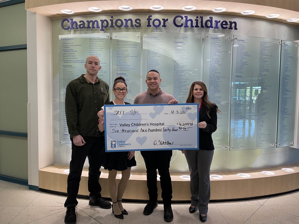 Four SATF staff stand with large check to Valley Children's Hospital for $6,244.42