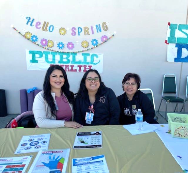 3 SATF public health staff members sit at table with resources