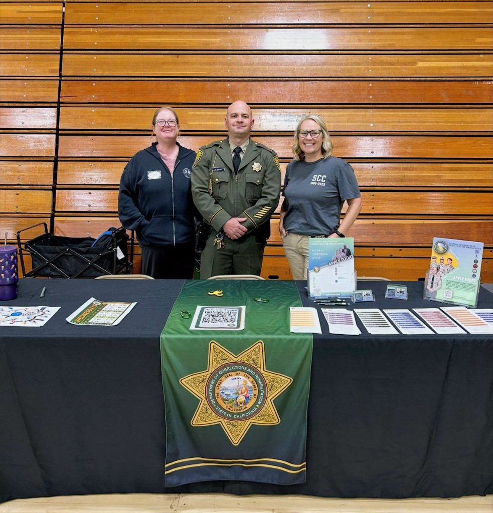 SCC staff at career fair standing at booth with resource materials on table