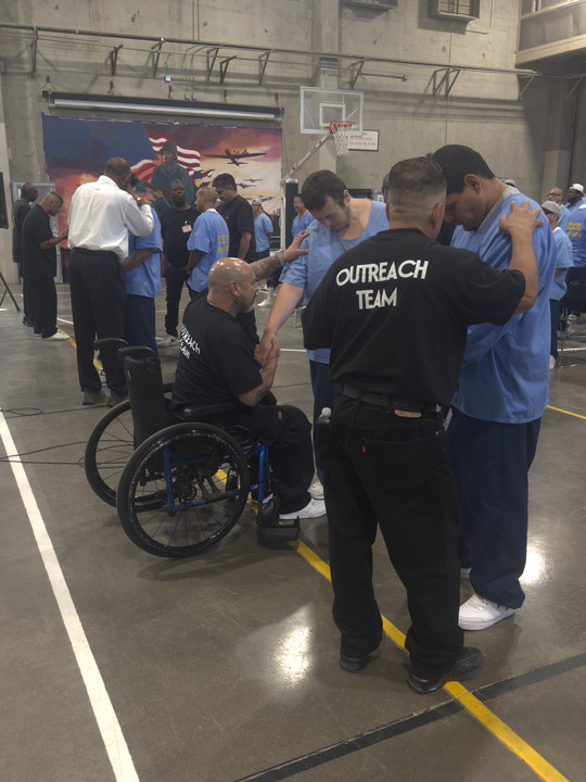 Group of staff, incarcerated and HOPE program members gather together and pray together
