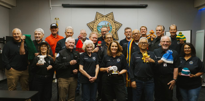Staff holding items donated by ASP crochet program