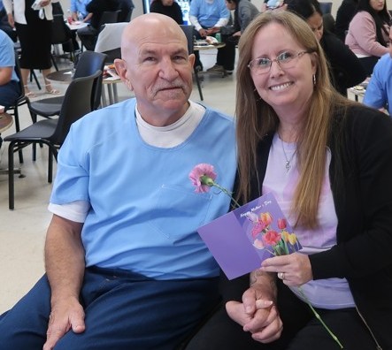 A couple holds hands during Mother's Day visiting at Avenal State Prison.