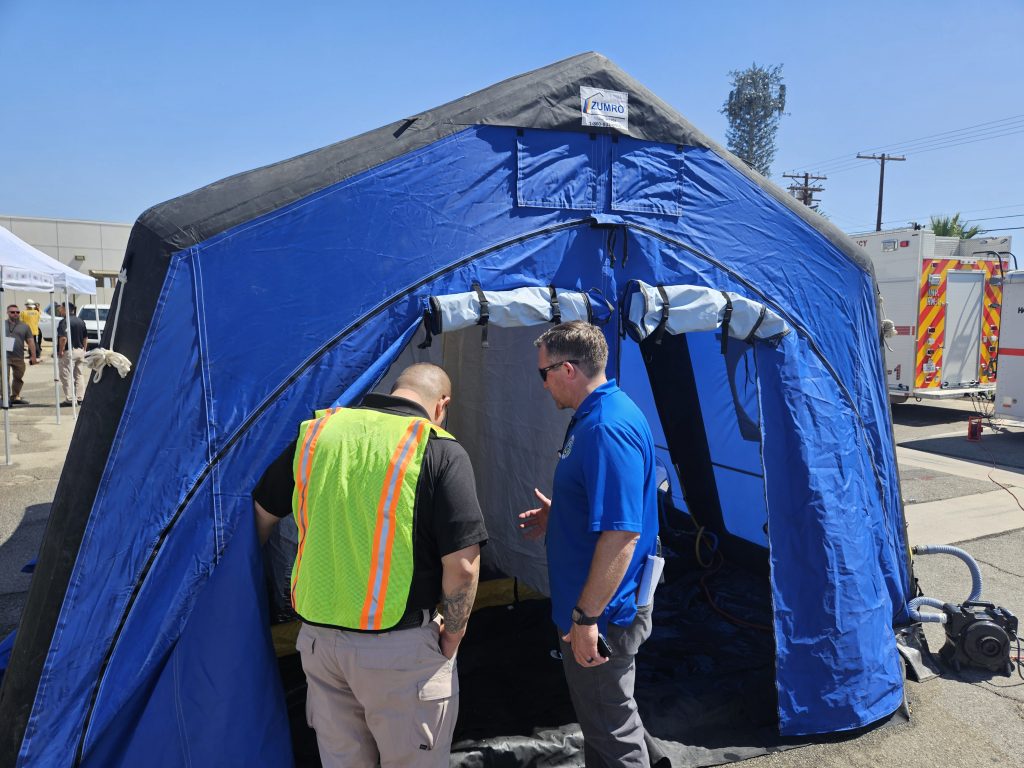 Training for a mass chemical exposure incident. Two staff members entering a tent.