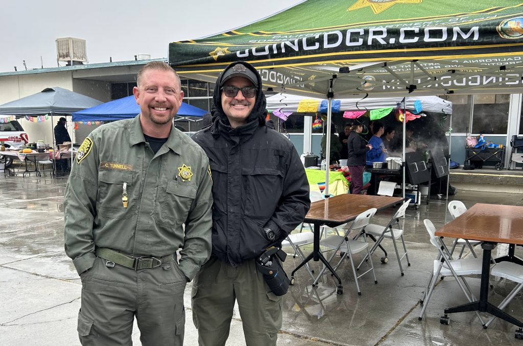 Rain during a staff appreciation event at CCI-Tehachapi with two staff members smiling. 