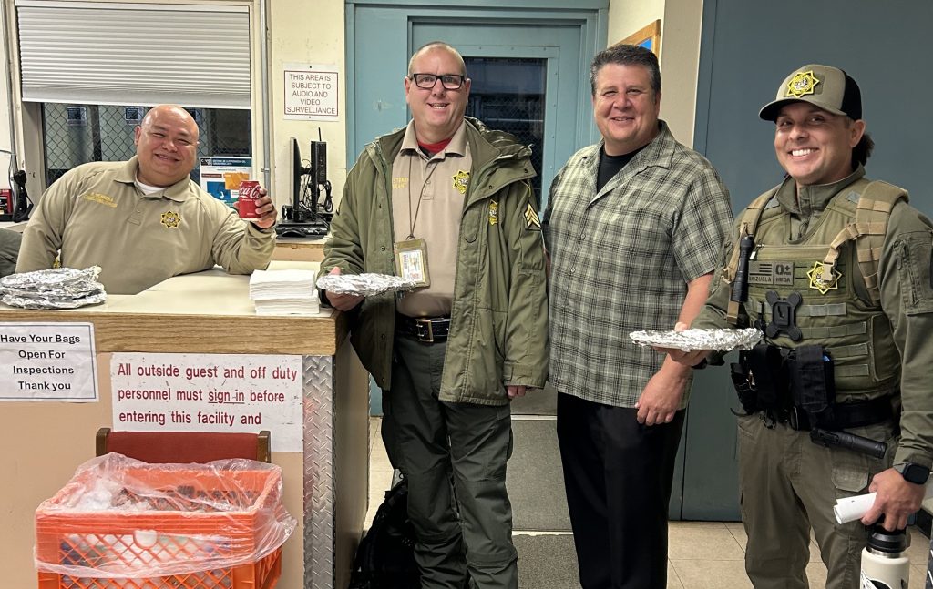 Group photo of four staff members with pizza at CCI.