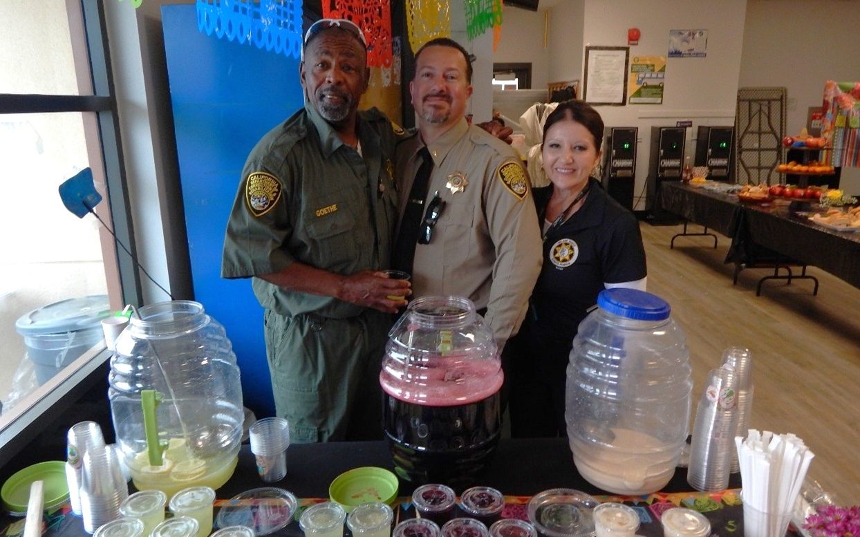 CCWF in Chowchilla shows staff appreciation as three people stand behind a table offering Agua fresca beverages.