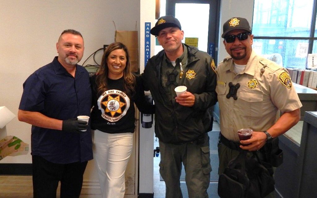 Four people pose for a photo at CCWF in Chowchilla.