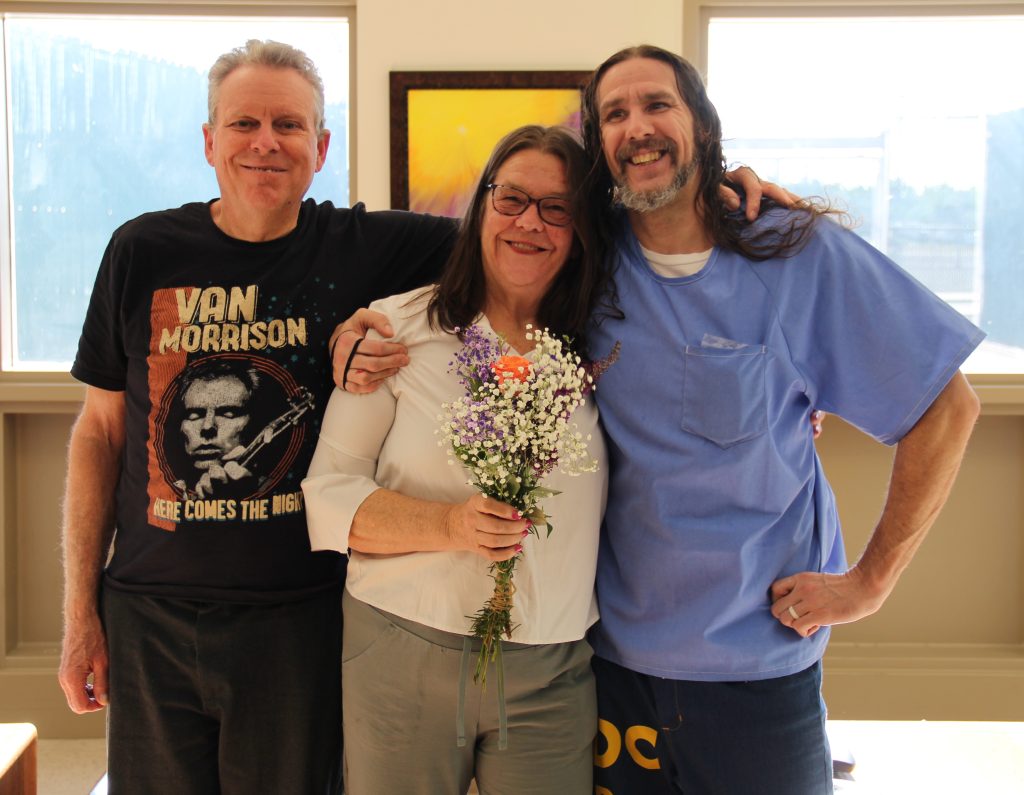 Two people and an incarcerated person during visiting at CHCF.