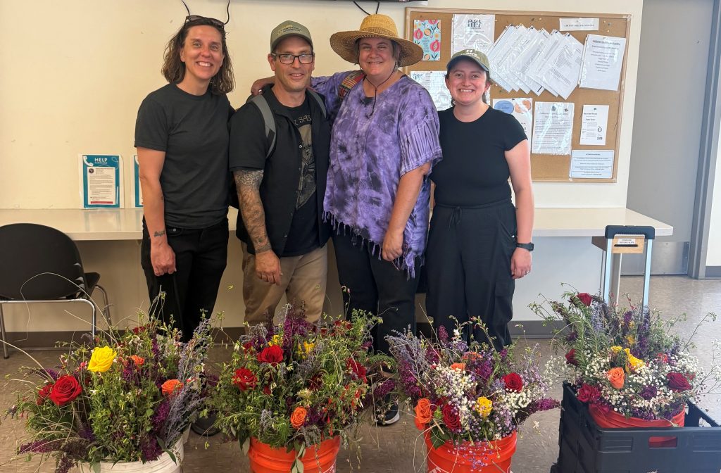 Land Together, four people and their bouquets they handed out to moms as they were leaving CHCF's visiting room on Mother's Day.