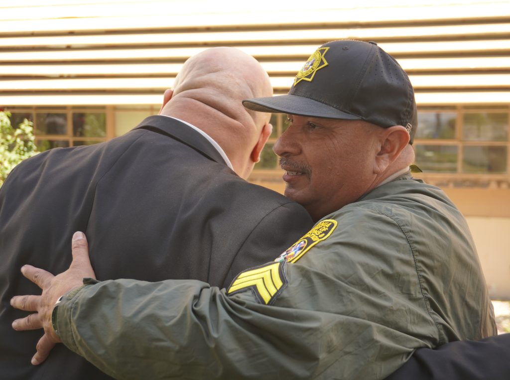 A correctional sergeant hugs the warden at California Institution for Men at Chino during a staff appreciation event.