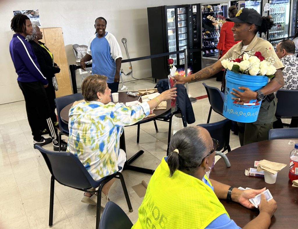 Staff member hands out flowers to visiting mothers and grandmothers at CIW.