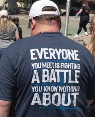 Participant at the Out of the Darkness Suicide Prevention Campus Walk wearing a shirt that reads "Everyone you meet is fighting a battle you know nothing about"
