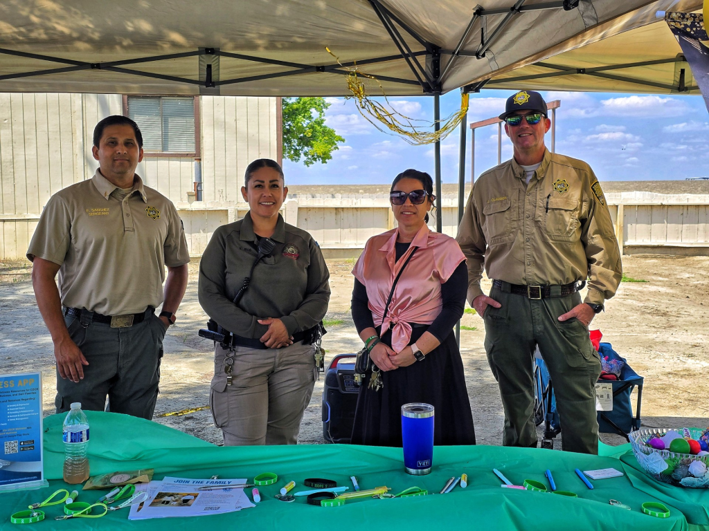 Group photo of staff behind a table at CSP-Corcoran.