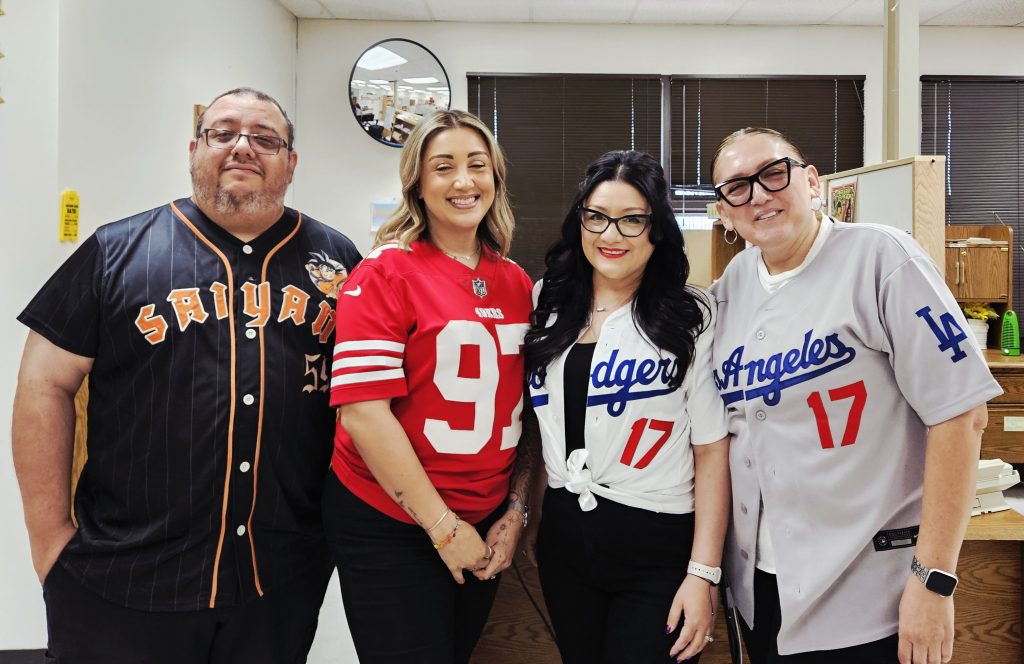 Four people wearing sports jerseys at Centinela State Prison.
