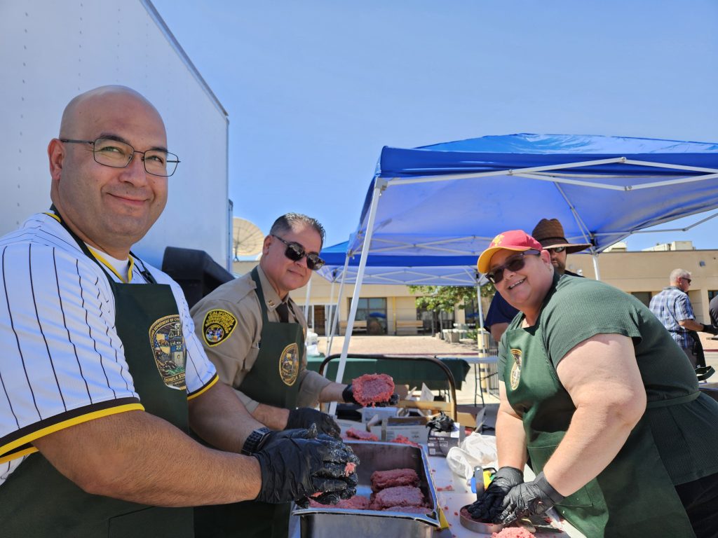 Managers and supervisors grill food for staff at Centinela State Prison.