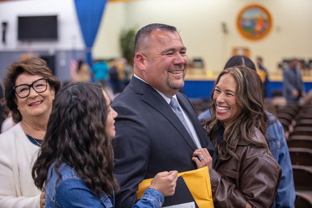 A parole agent is surrounded by family after the graduation ceremony.