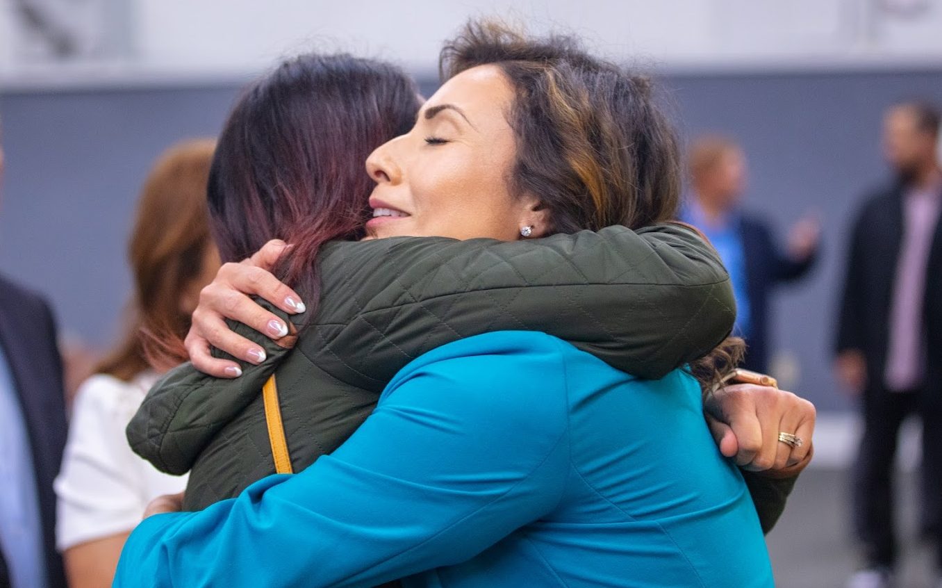 A parole agent hugs a family member.