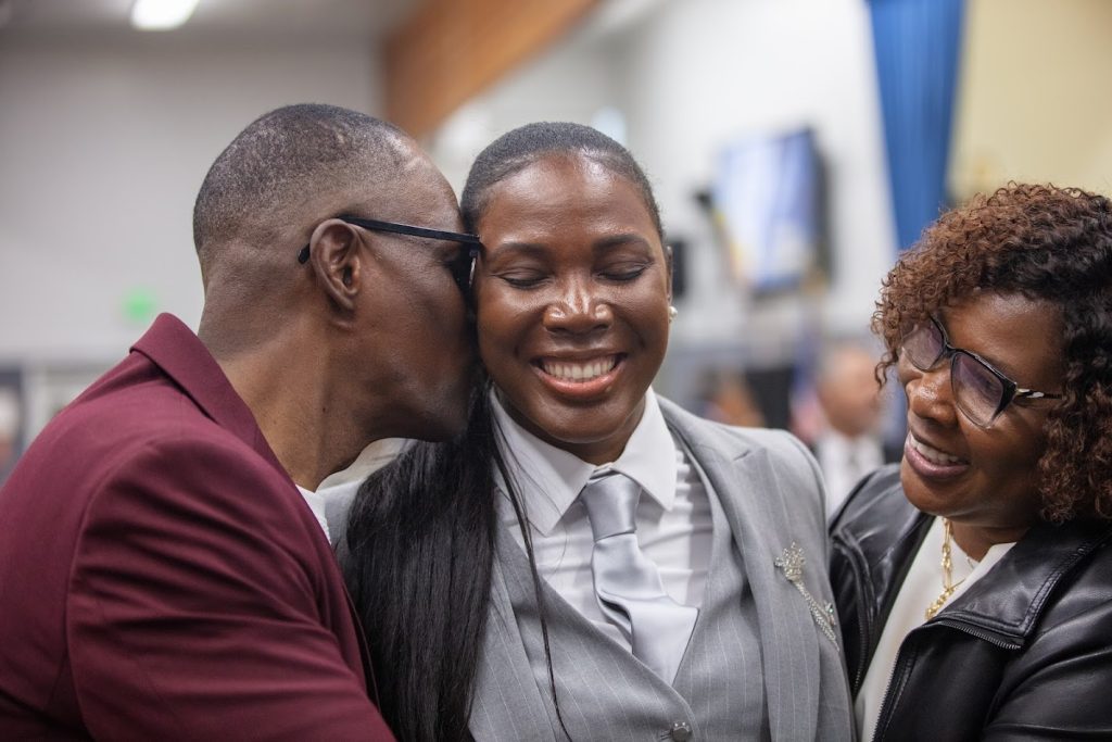 Family members hug their graduating parole agent.