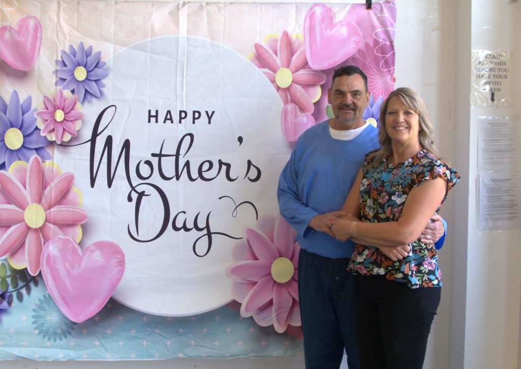 An incarcerated person and a woman pose for a photo on Mother's Day at High Desert State Prison in Susanville, California.