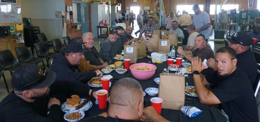 A group photo of Plant Operations staff enjoying lunch together.