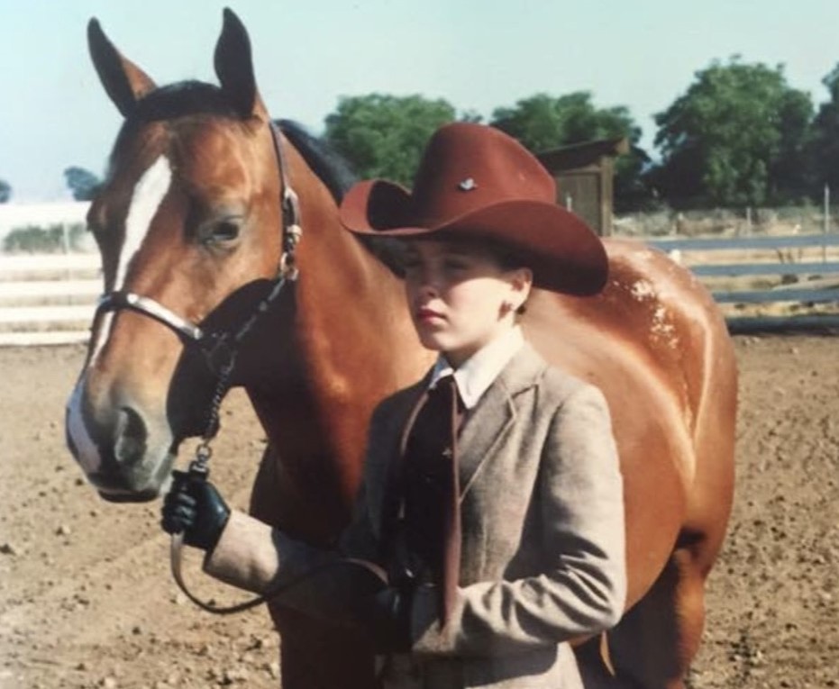 Molly Coyle when she was a child standing beside her horse.