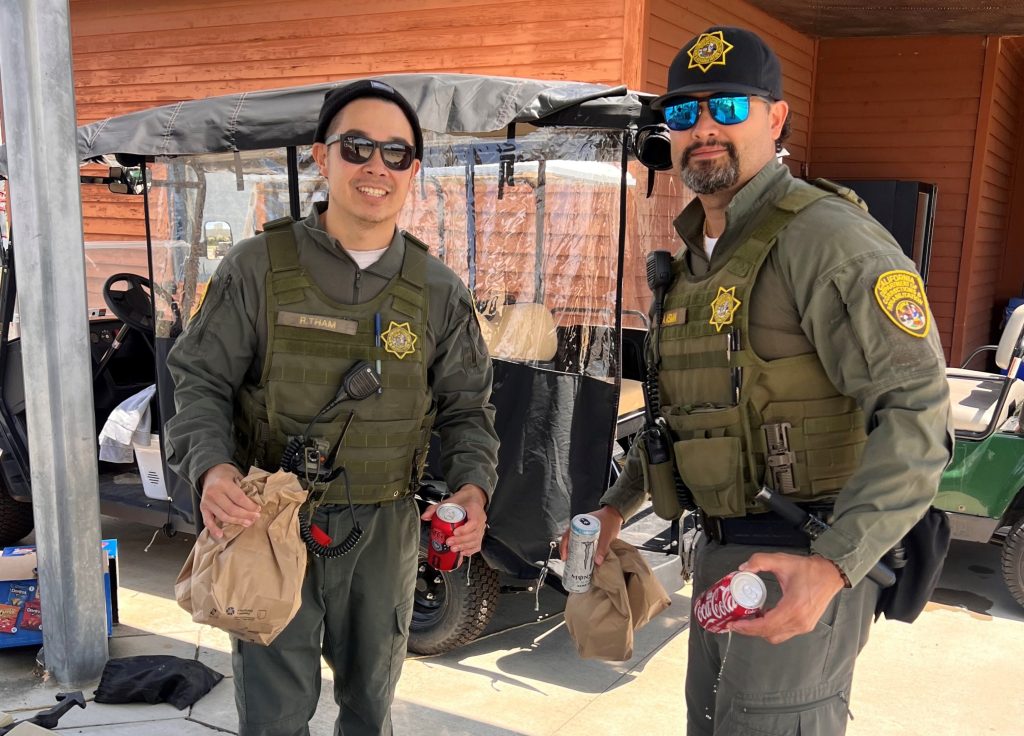 Two people carry food at the Mule Creek State Prison event.