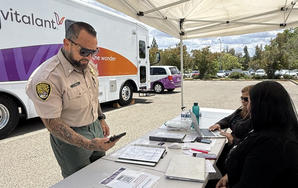A correctional officer scans the QR code to register for the blood drive at Mule Creek State Prison.