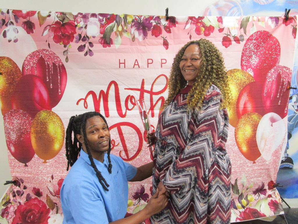 Special Mother's Day visiting with an incarcerated person presenting a flower to a visiting woman at CSP-Sacramento.
