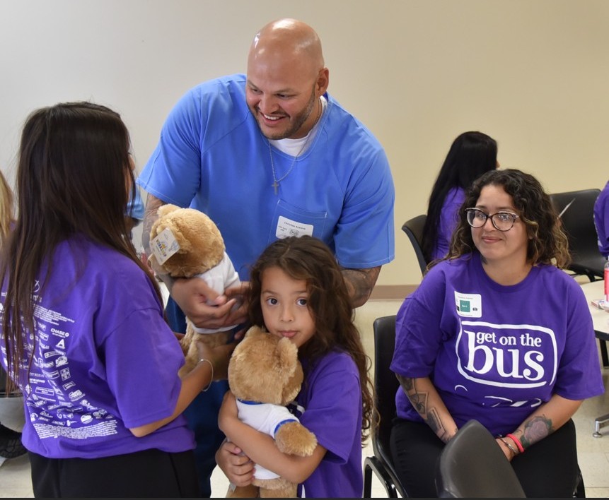 Giving stuffed bears to children at Avenal State Prison.