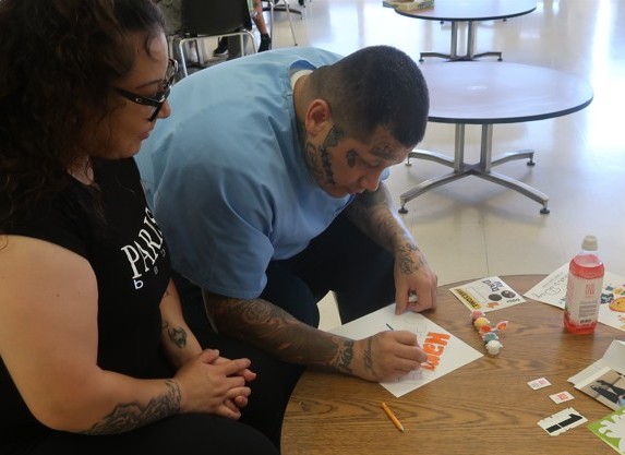 People doing crafts during Father's Day visiting at Avenal State Prison.