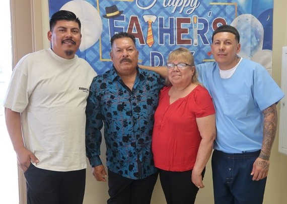Three people visiting their incarcerated loved one for Father's Day at Avenal State Prison.