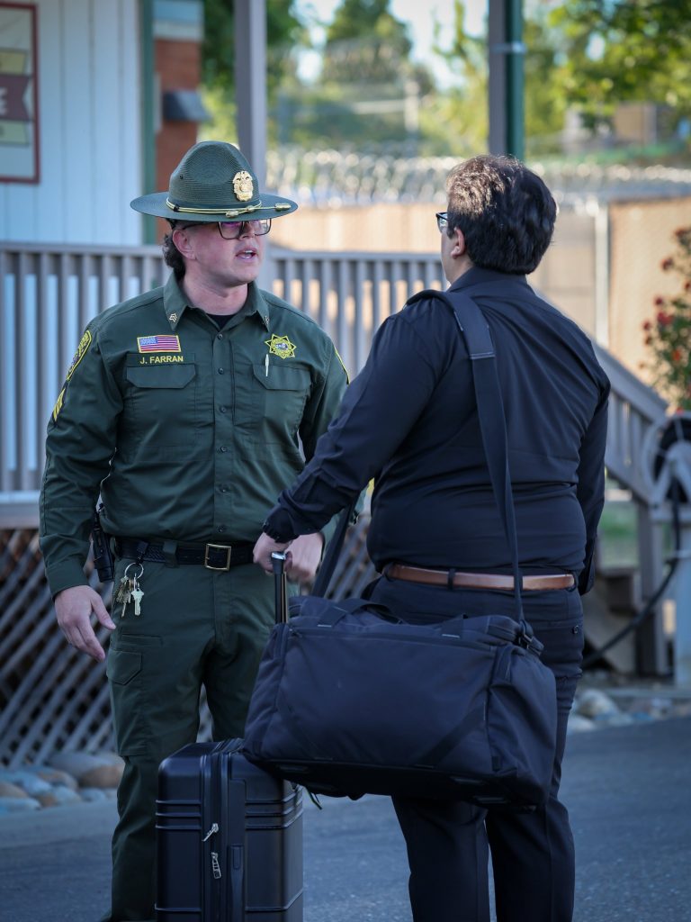 A cadet carries his bags as he checks in with a sergeant.