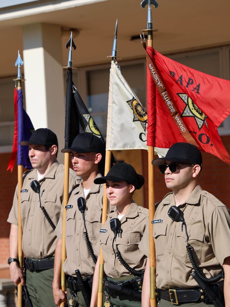 Four cadets carry guidons for their respective companies of Class 3-26A at the CDCR Academy.