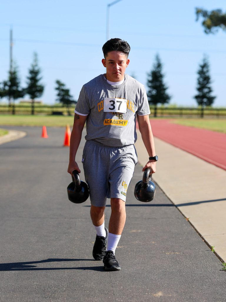 Carrying weights at the Academy track.