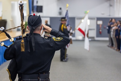 Bagpiper saluting at Basic Parole Agent Academy graduation