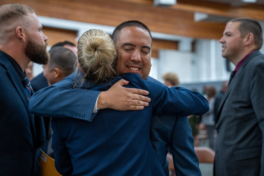 Two new parole agents hug after graduating the academy.