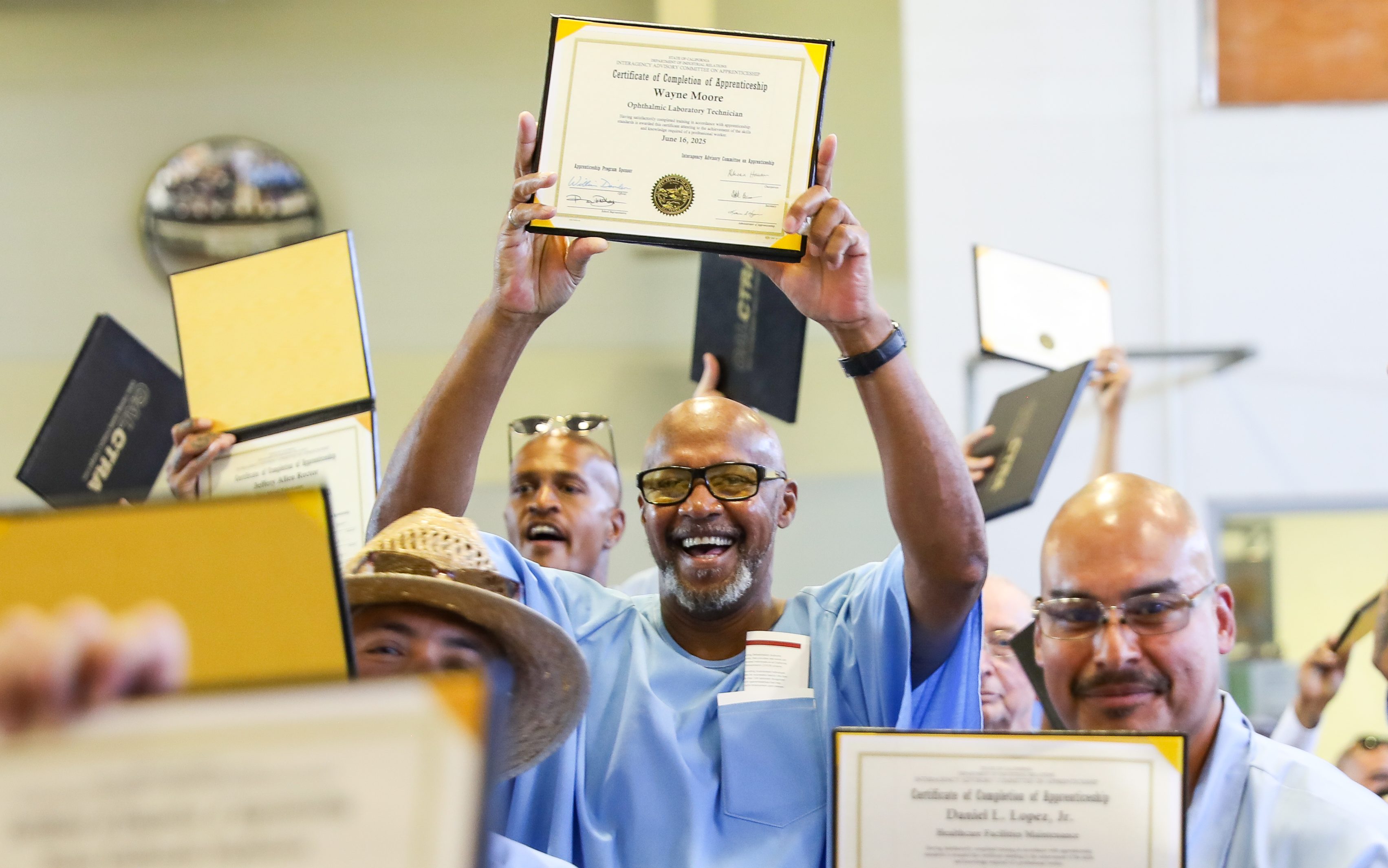 A graduate proudly holds his certificate at the CALCTRA graduation ceremony at CSP-Solano.