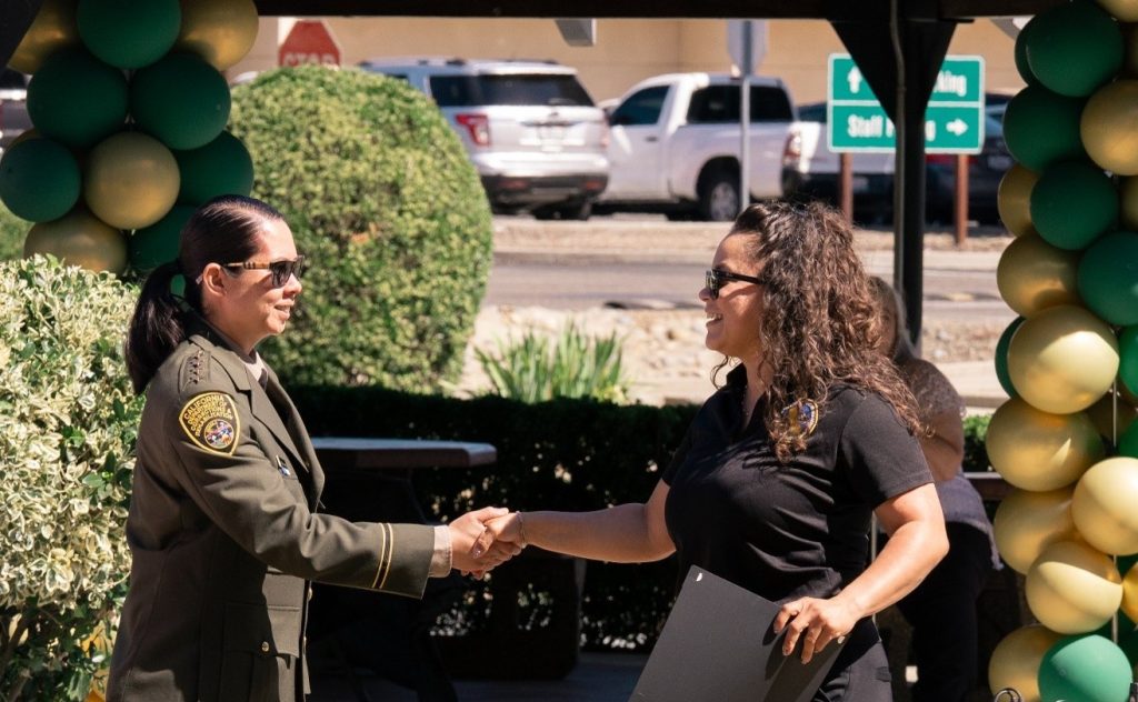 Warden De La Cruz shakes hands with a staff member during the promotion ceremony at Central California Women's Facility in Chowchilla.