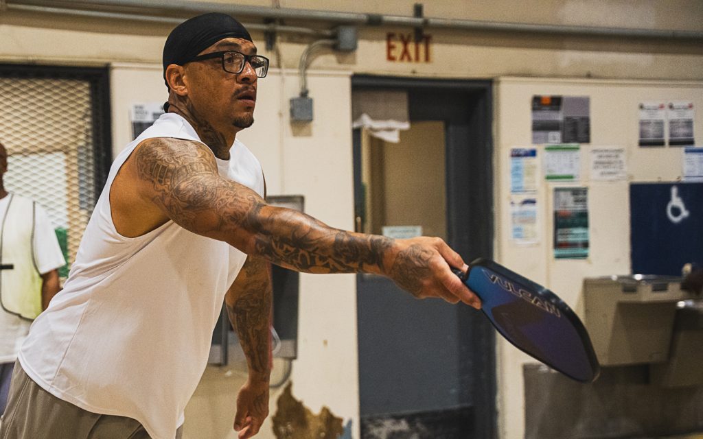 An incarcerated person at California Institution for Men in Chino plays a round of pickle ball in a tournament.