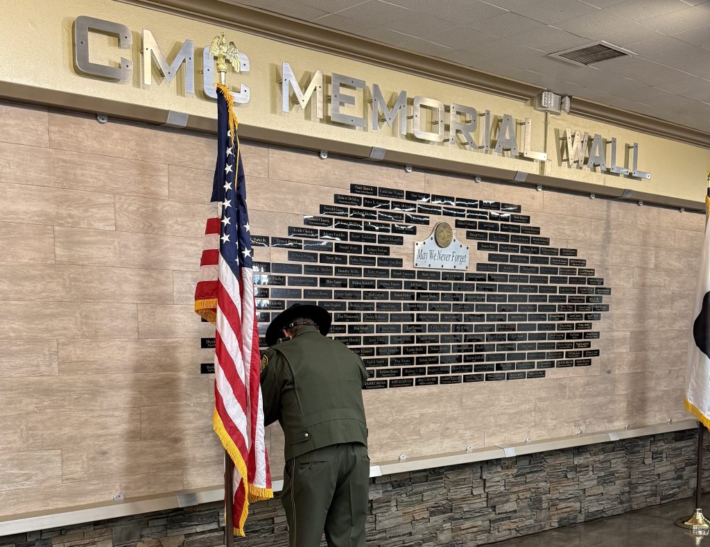 A correctional officer adds a name to the wall at CMC.