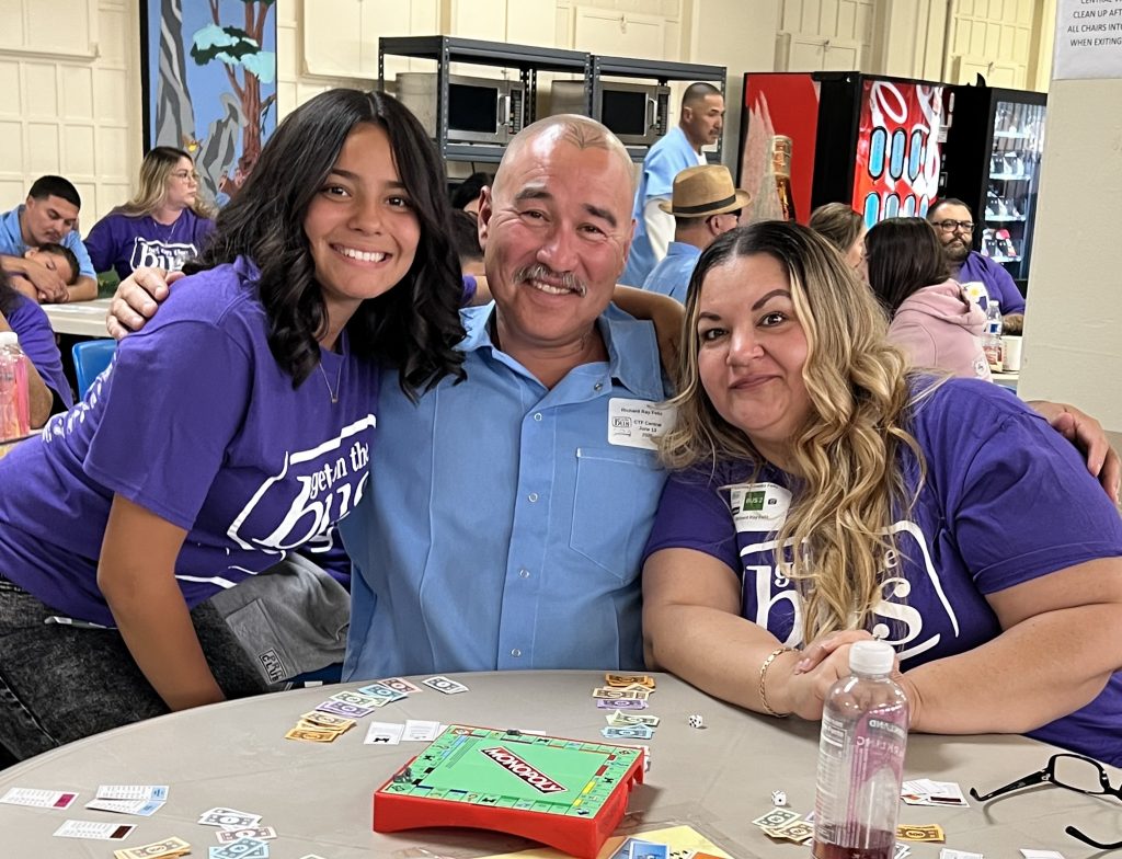 Hugging around a table at CTF-Soledad during a visiting event.
