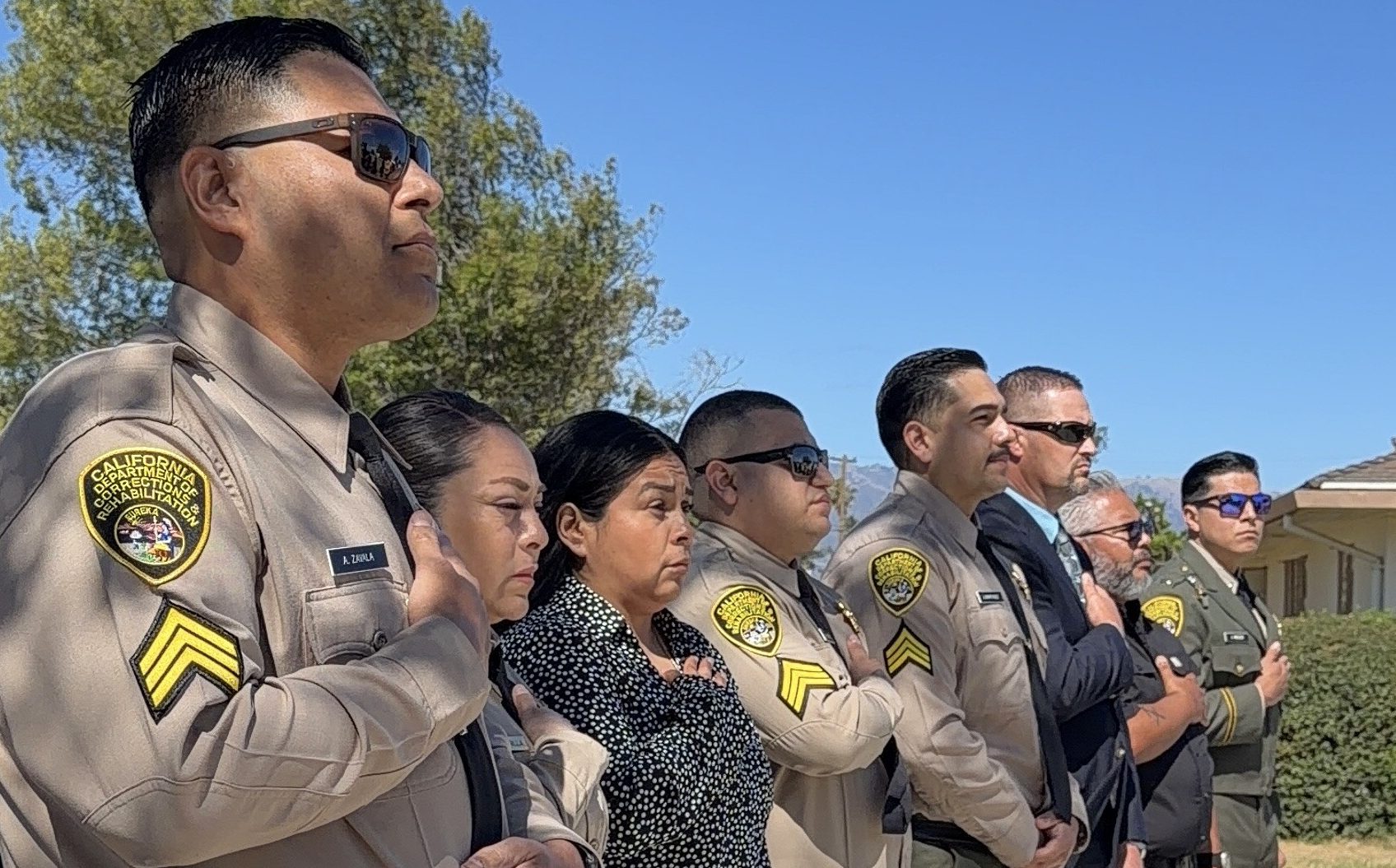 Staff members hold hands over hearts during the opening of the CTF promotional ceremony.