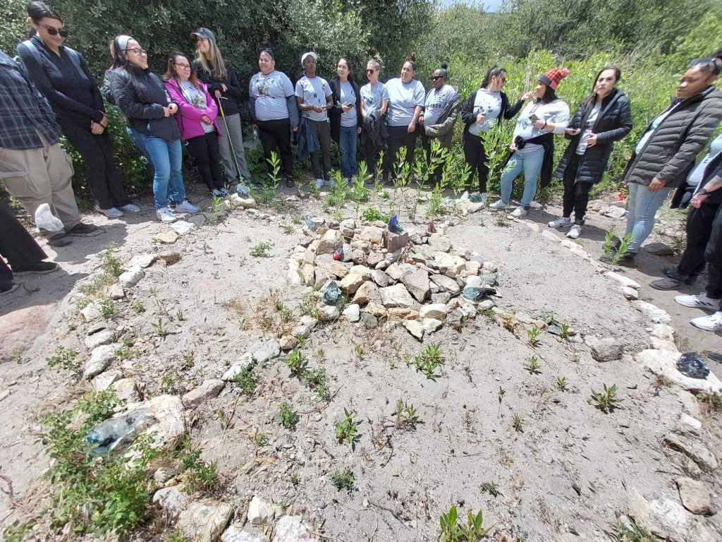 Women gather at a monument of rocks at the Wolf Connection sanctuary.