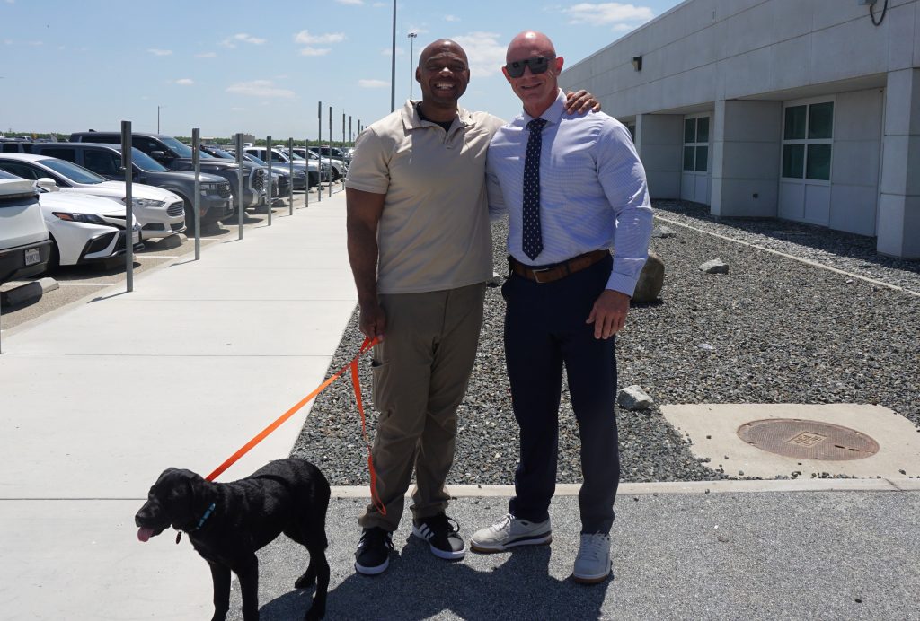 Warden Pat Horn, Kern Valley State Prison, with a representative from the Canine Companion dog training program and a puppy.