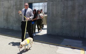Chief Deputy Warden Steve Cramner walks in with one of the dogs beginning the Canine Companion Kern Valley State Prison program.