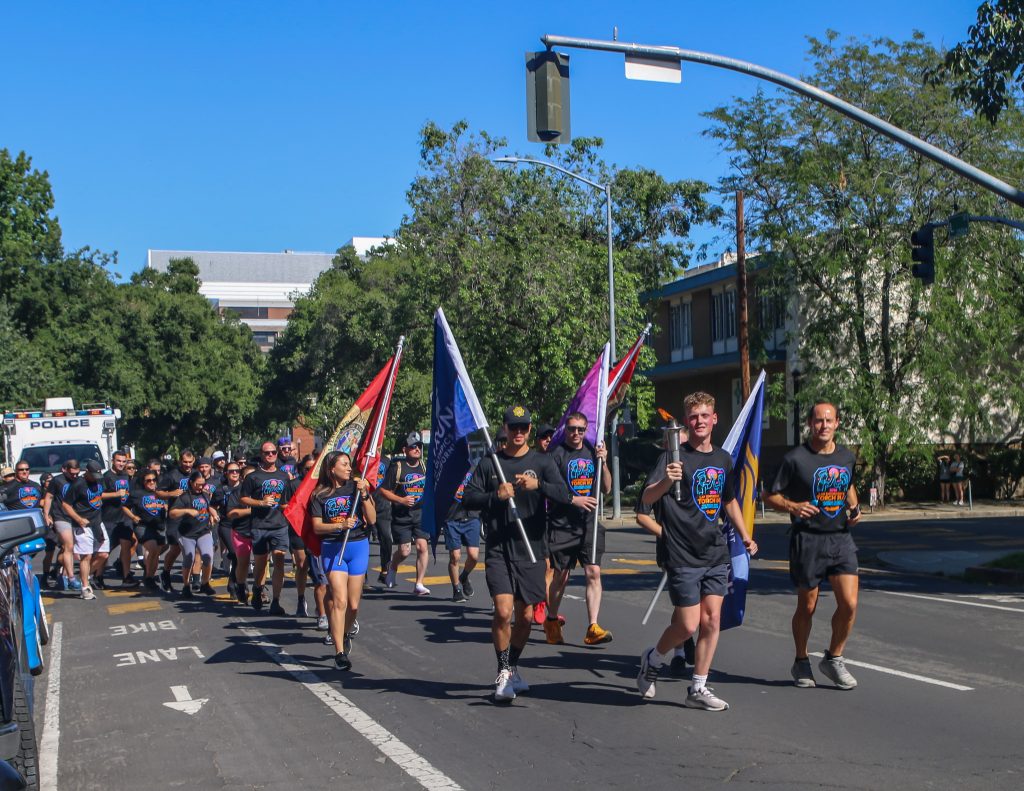 Runners carry flags during the Capitol leg of the 2026 Law Enforcement Torch Run.